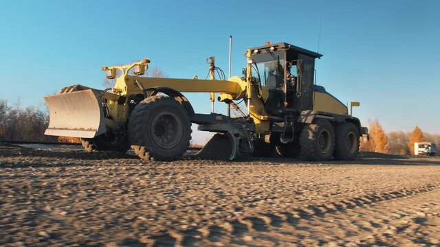 Grader with 3D GPS System. Satellite navigation. A motor grader levels bulk building materials for a new road construction. Road surface repair. Road construction machines. Road works