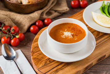 Tomato soup with cheese in white porcelain bowl.