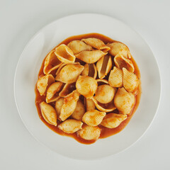 pasta on a white plate with tomato sauce
