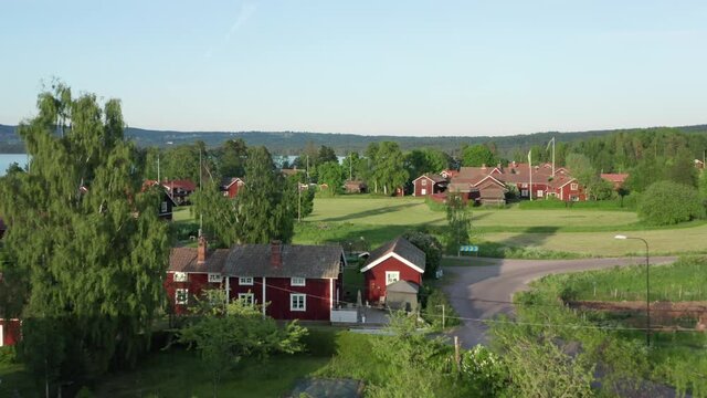 Swedish village red house drone shot. Aerial view lake typical wooden homes