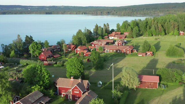 Swedish village red house drone shot. Aerial view lake typical wooden homes