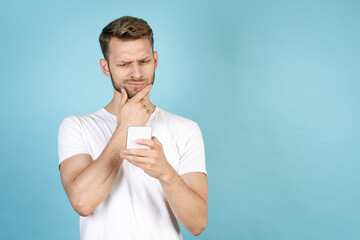 Thoughtful adult man using online app on modern smartphone