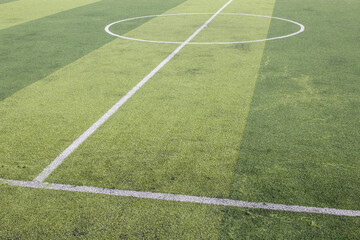 Fototapeta premium Photo of a green synthetic grass sports field with white line shot from above.