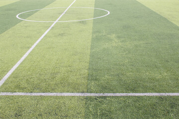 Obraz premium Photo of a green synthetic grass sports field with white line shot from above.