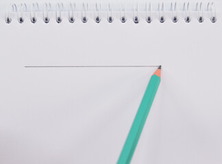 Pencil draws a line on a piece of notebook