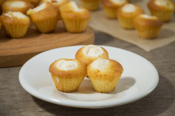 Fresh homemade delicious small muffins with cottage cheese cream. Fresh pastries on on a white plate. Sweet dessert. Enjoy your meal.