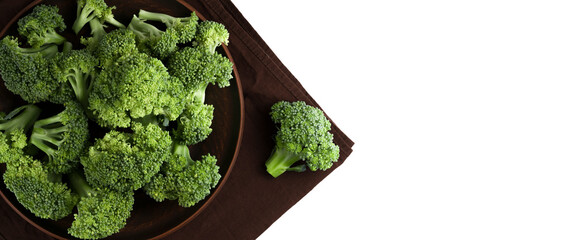 Top view of tasty organic broccoli on brown plate isolated on white background