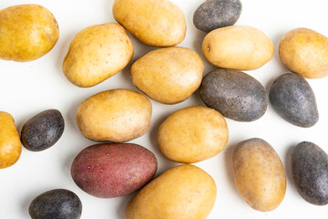 Fototapeta na wymiar Assorted Color Potatoes On Flat White Surface Table