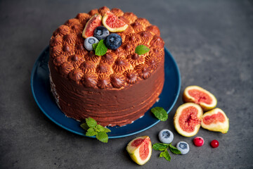 cheesecake in chocolate glaze and figs on dark gray background