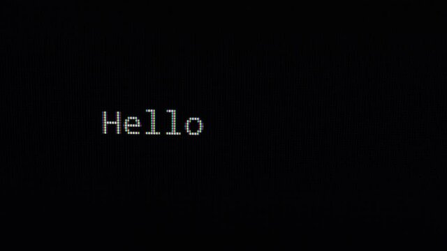 Typing hello world text on black screen close up 4k footage. Typing The Classical Programmers' Greeting Message.