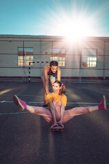 Fototapeta na wymiar Two teen girls have fun with skate board