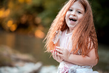 Adorable, ginger little girl smiles and shows missing front teeth