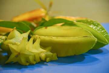 Star fruit (Averrhoa carambola) on blue surface on yellow background