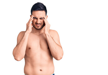 Fototapeta premium Young handsome man wearing swimwear with hand on head, headache because stress. suffering migraine.