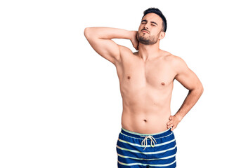 Fototapeta premium Young handsome man wearing swimwear suffering of neck ache injury, touching neck with hand, muscular pain