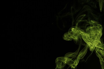 yellow smoke from incense on a black background