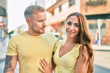Young couple smiling happy hugging at street of city.