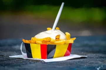 Foto op Plexiglas Paper box in colors of Belgian flag with fried potato frit chips and mayonnaise sauсe. © barmalini