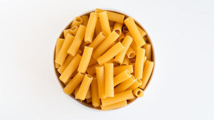 Raw dry uncooked Tortiglioni pasta spaghetti noodle on white bowl wooden background for basil tomato pesto sauce Homemade Italian food organic whole wheat vegan spaghetti for a healthy meal