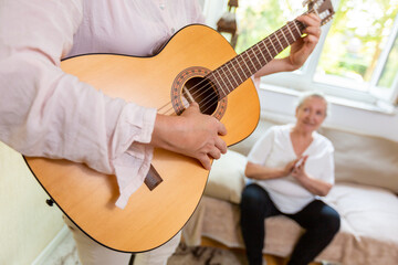 a woman plays something on the guitar for an old lady
