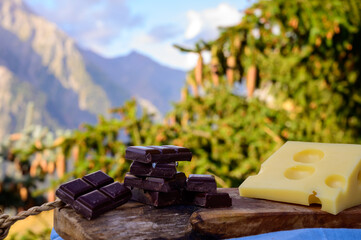 Handmade pure dark swiss chocolate and Alpine mountains on background