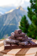 Handmade pure dark swiss chocolate and Alpine mountains on background