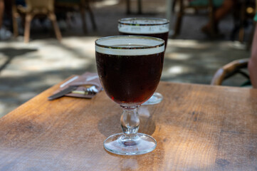 Glasses with cold dark strong Belgian beer served outdoor