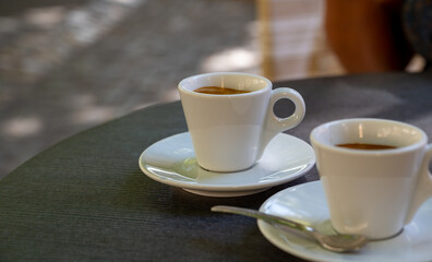 Drinking of strong black espresso coffee on outdoor terrace in cafe