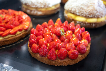 Assortment of french fresh baked sweet pastry with fresh fruits and berries in confectionery shop