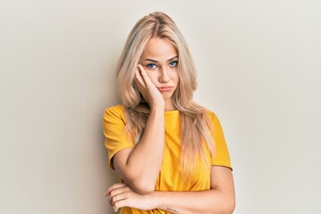 Beautiful caucasian blonde girl wearing casual tshirt thinking looking tired and bored with depression problems with crossed arms.