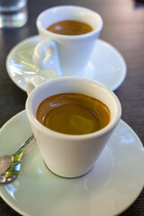 Drinking of strong black espresso coffee on outdoor terrace in cafe