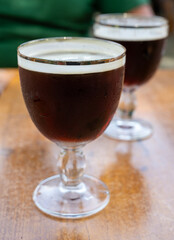 Glasses with cold dark strong Belgian beer served outdoor