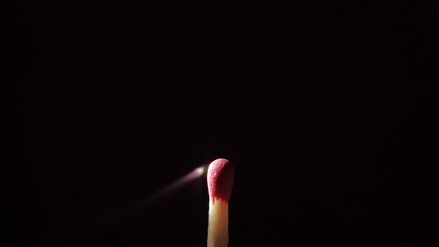 Close up of an isolated Match stick catching fire from start to finish against a black background.