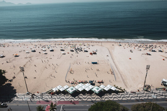 Beautiful view of Copacabana beach from above looking towards the sea; Rio de Janeiro, Brazil. Detail of restaurant tents and tourists at the beach. New normal covid reopening concept.