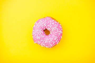 Bright pink delicious donuts on a yellow background