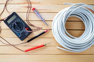 electrician tools and accessories on a wooden desk. electric service concept. above view