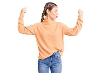 Beautiful caucasian woman with blonde hair wearing casual winter sweater showing arms muscles smiling proud. fitness concept.