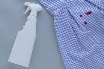 dirty blood stains on dress and stain remover.isolated on gray background