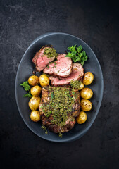 Traditional English barbecue lamb roast sliced with mint sauce and boiled potatoes sauce offered as...