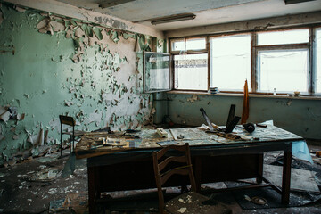 Creepy abandoned office room inside with old wooden table and windows. Horror concept.