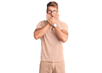 Young caucasian man wearing casual clothes and glasses shocked covering mouth with hands for...