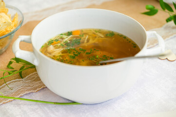 Beef broth with noodles and dumplings in a bowl.