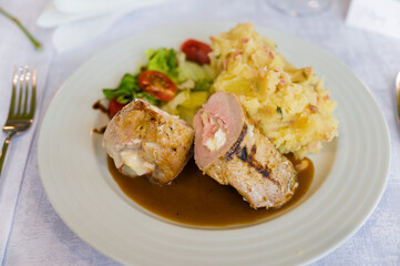 Stuffed meat with side dish and mashed potatoes.
