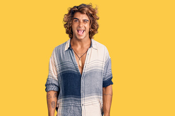 Young hispanic man wearing summer style winking looking at the camera with sexy expression,...