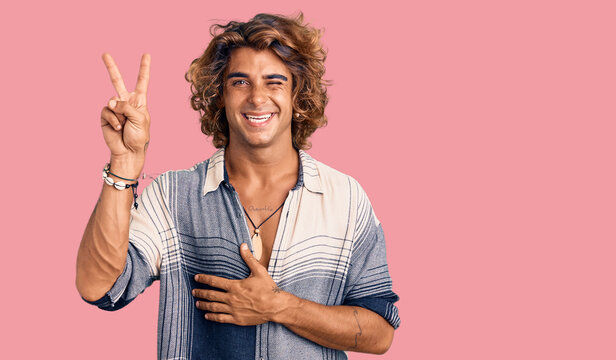 Young hispanic man wearing summer style smiling with happy face winking at the camera doing victory sign. number two.