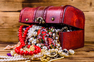 Old box of red wood full of the jewelry. Treasure chest