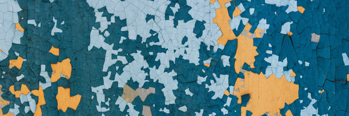 Peeling paint on the wall. Panorama of a concrete wall with old cracked flaking paint. Weathered rough painted surface with patterns of cracks and peeling. Wide panoramic grungy texture for background