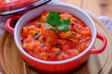 Vegetable stew in a beautiful red saucepan.