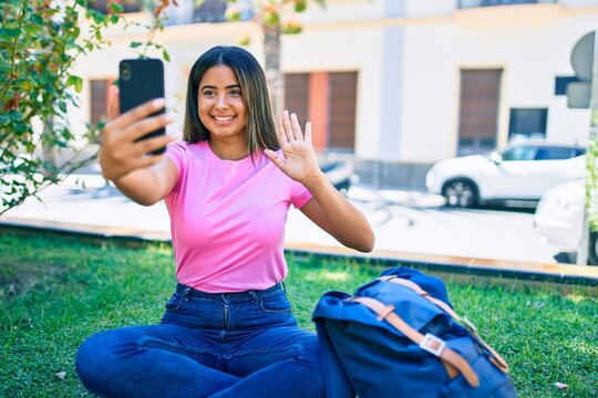 Young latin student girl smiling happy doing video call using smartphone at university campus.