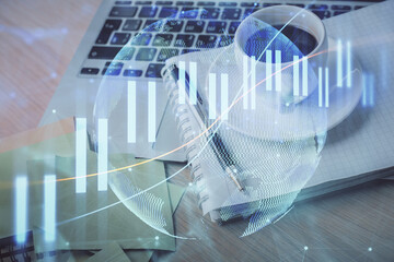 Double exposure of forex chart drawing and desktop with coffee and items on table background. Concept of financial market trading